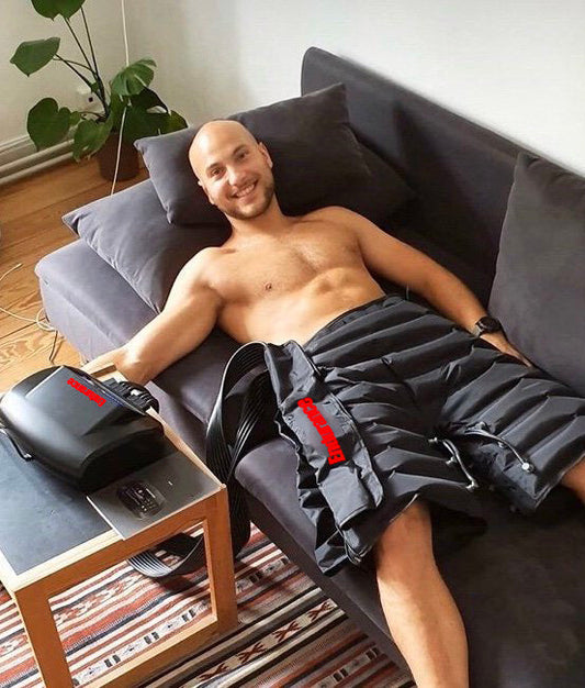 A man is lying on the couch wearing Recovery Shorts